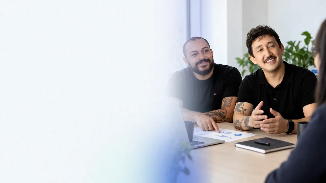 Filipe Osanai e Felippe Cassiano, sócios da Draivv, numa reunião de trabalho com uma cliente, no escritório.